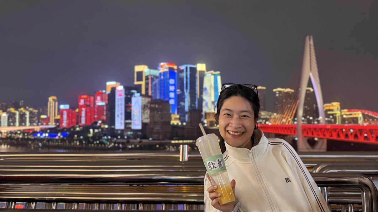Nụ cười trong đêm Hồng Nhai Động, phía sau là cầu Thiên Tư Môn và skyline Giang Bắc Chủy